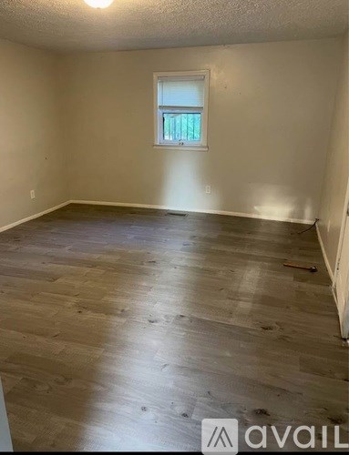 A room with wooden flooring and a window.