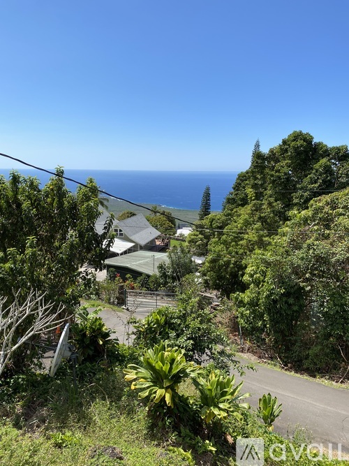 A house is situated on a hill with a view of the ocean.