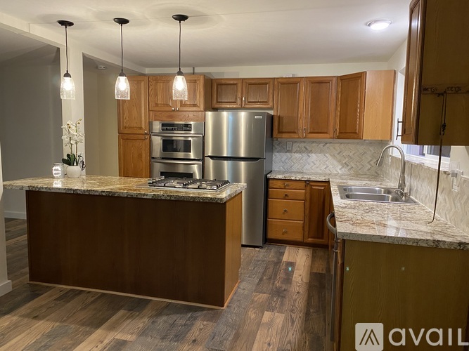 A kitchen with wooden cabinets and a granite countertop.