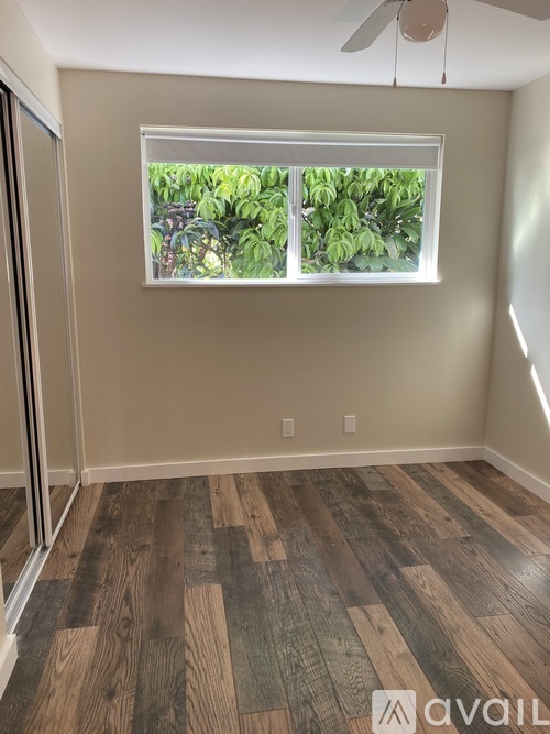 A room with a window and wooden flooring.
