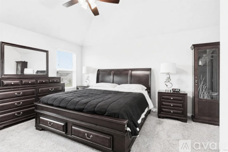 A bedroom with a large bed, dresser, and mirror.