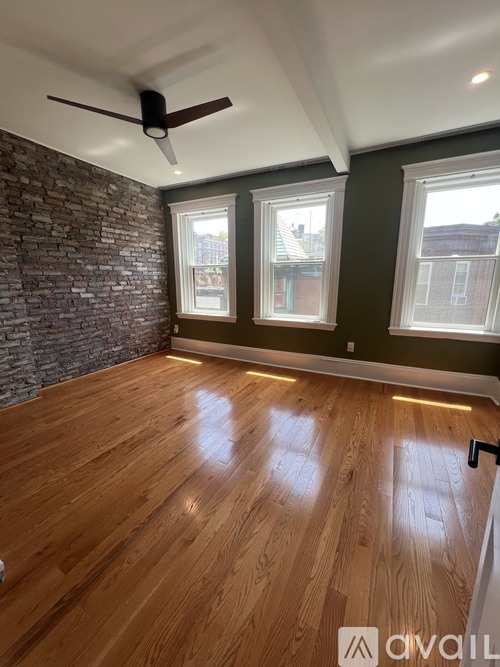 A room with wooden floors and a ceiling fan.
