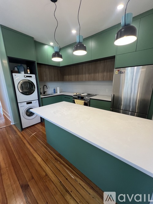 A kitchen with a washing machine and a refrigerator.