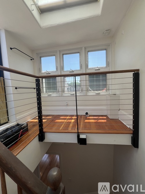 A balcony with a wooden floor and black railings.