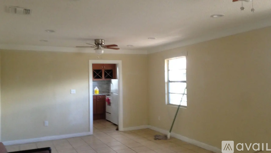 A room with a ceiling fan and a window.