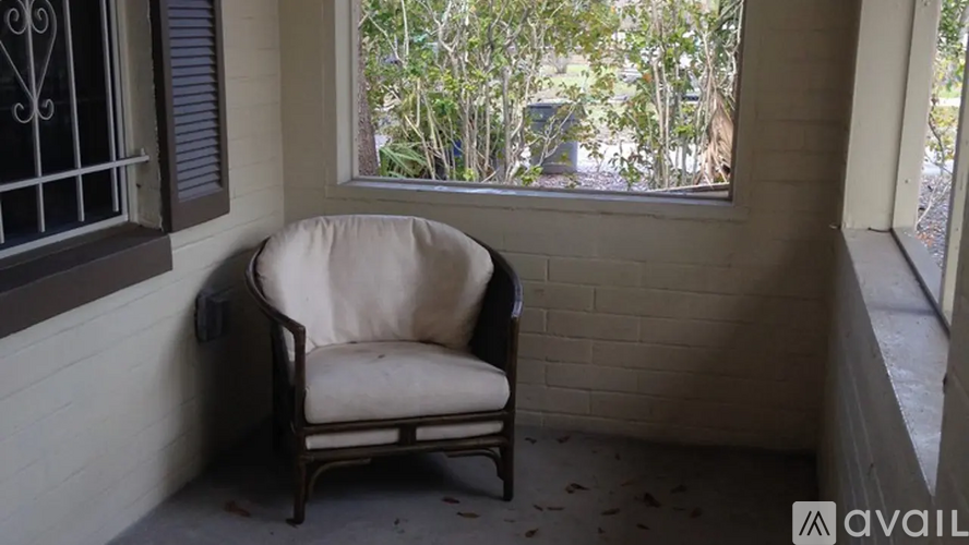 A white chair is placed in front of a window.