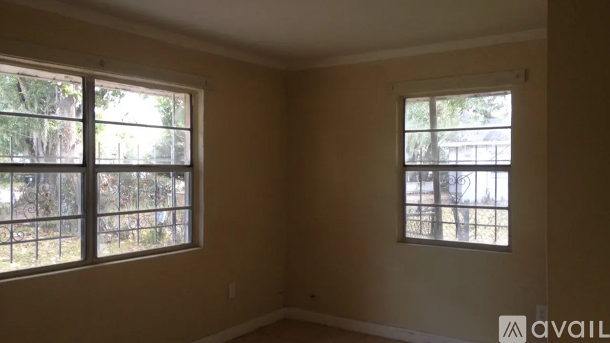 A room with two windows and a sign that says "available".