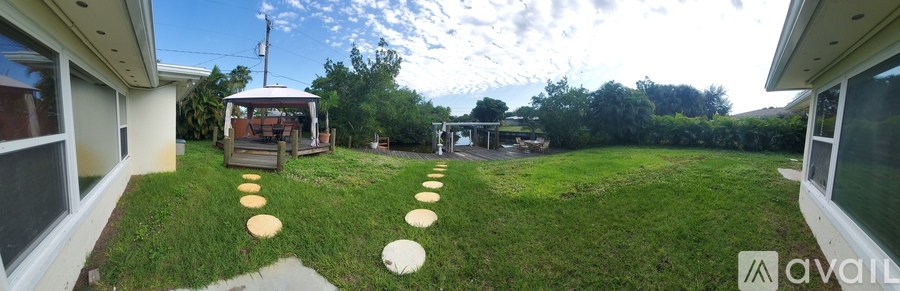 A backyard with a gazebo and stepping stones.