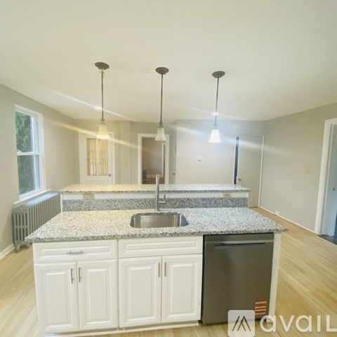 A kitchen with granite countertops and white cabinets.