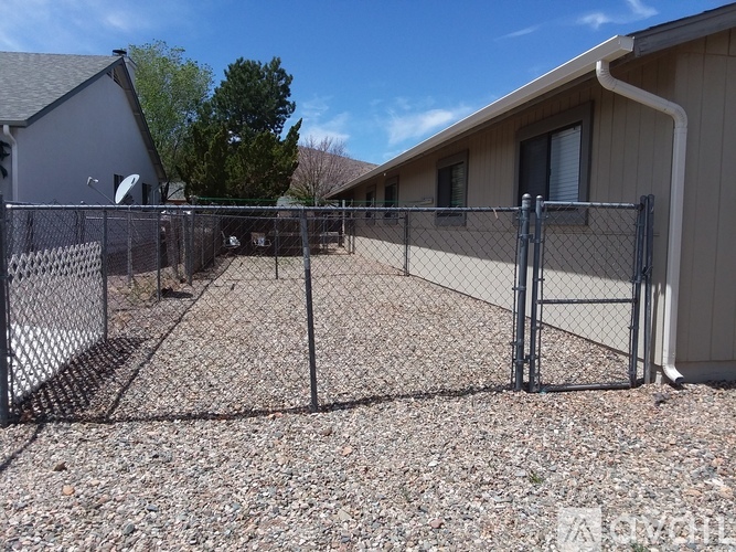 A chain link fence surrounds a gravel yard.