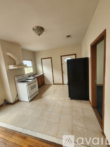 A kitchen with a black fridge, white stove and a white dishwasher.