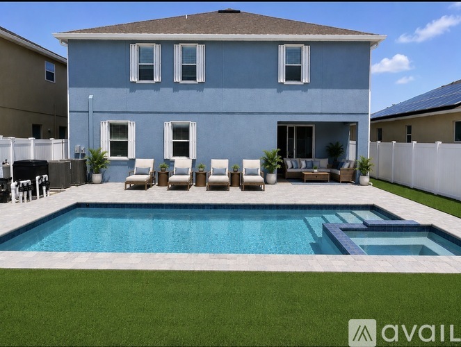 A blue house with a pool in the backyard.
