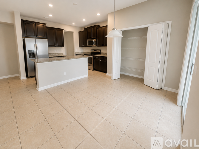 A spacious kitchen with a refrigerator, microwave, and oven.