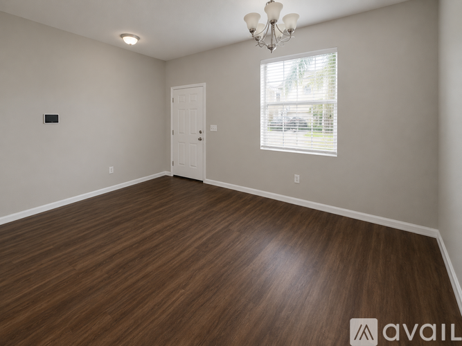 A room with wooden flooring and a chandelier.