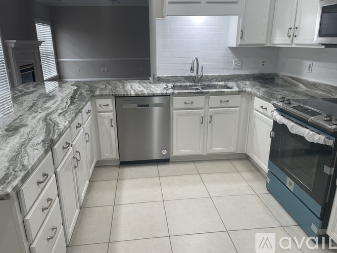 A kitchen with a marble countertop and white cabinets.