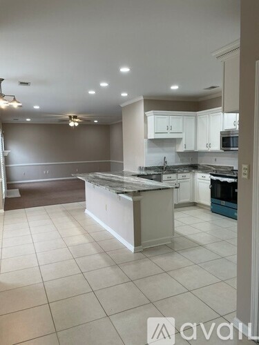A kitchen with white cabinets and a large island.
