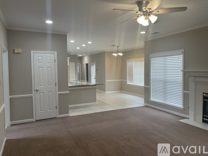 A spacious room with a ceiling fan and a fireplace.