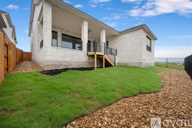 A modern house with a white exterior and a black metal fence.