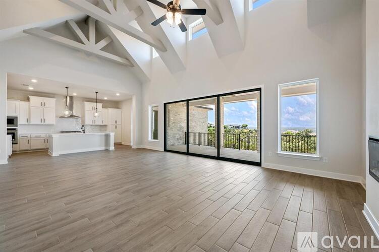 A spacious living room with a ceiling fan and sliding glass doors.