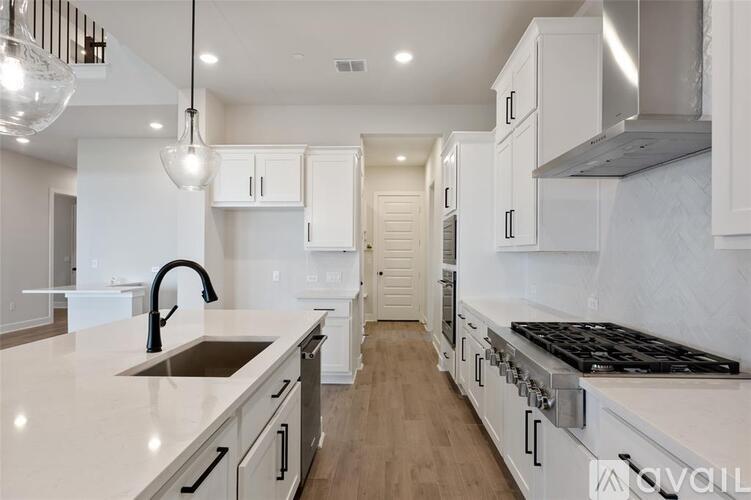 A modern kitchen with white cabinets and a stainless steel range hood.