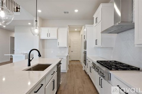 A modern kitchen with white cabinets and a stainless steel range hood.