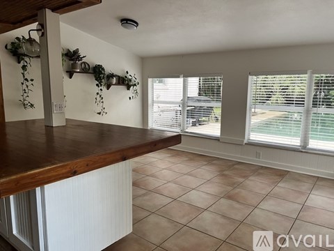 A kitchen with a wooden counter and white cabinets.