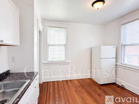 A kitchen with white cabinets and a wooden floor.