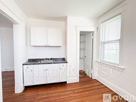 A kitchen with white cabinets and a granite countertop.