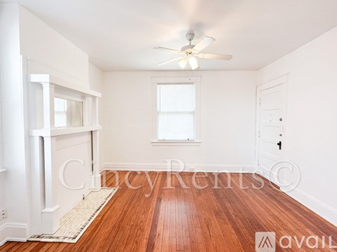 A room with a ceiling fan and wooden flooring.