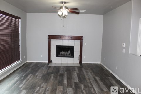 A room with a fireplace and a ceiling fan.