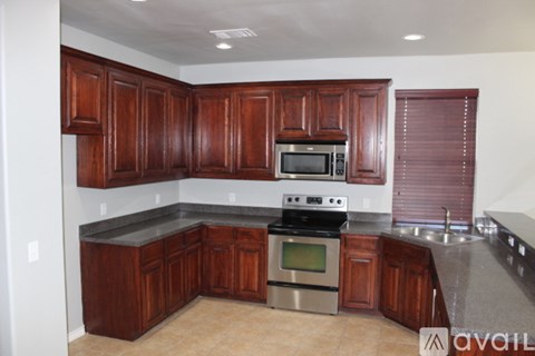 A kitchen with wooden cabinets and a stainless steel oven.