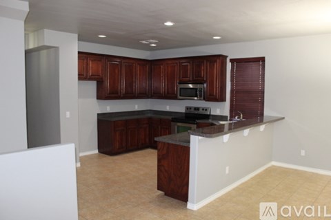 A kitchen with brown cabinets and a white refrigerator.