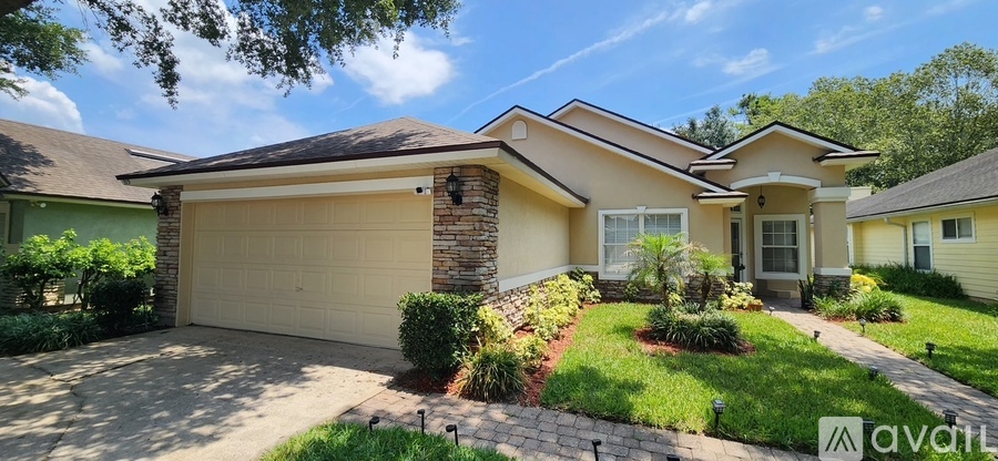 A house with a garage and a driveway in front of it.