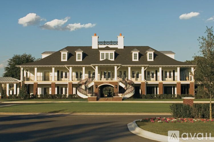 A large, two-story house with a wrap-around porch and a staircase leading to the entrance.