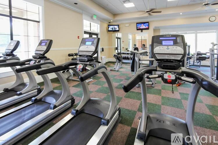 A gym with treadmilers and elliptical machines.