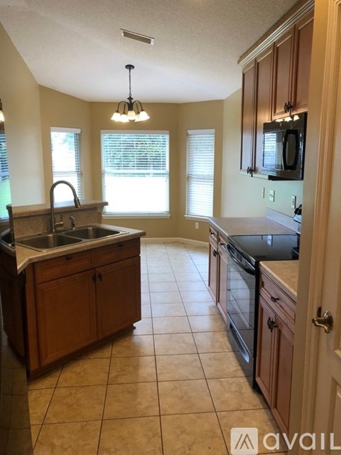 A kitchen with wooden cabinets and a tiled floor.