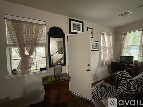 A living room with a zebra print chair and a dresser with a mirror.