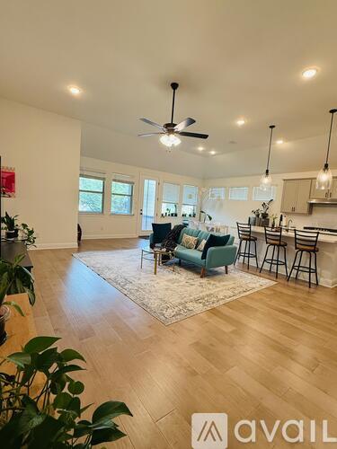 A living room with a couch, chairs, and a rug.