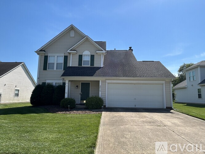 A two-story house with a garage and a driveway.