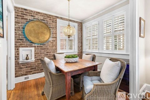 A dining room with a wooden table and chairs.