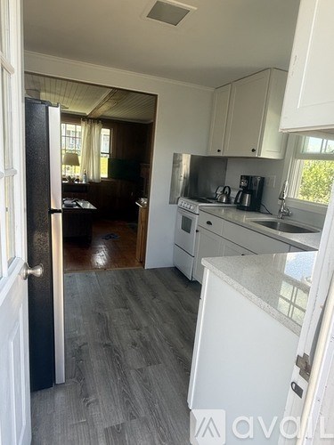 A kitchen with white cabinets and a black door.
