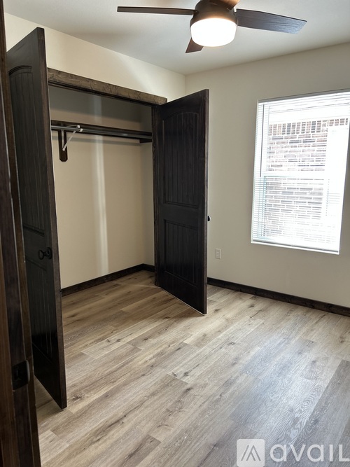 A room with a black door and a ceiling fan.