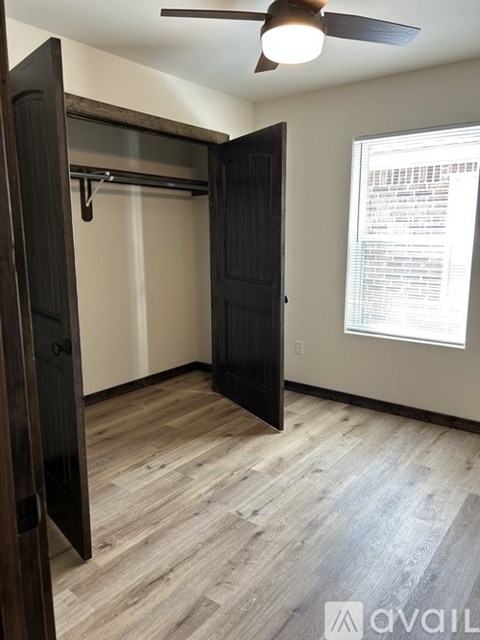 A room with a black door and a ceiling fan.