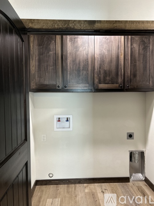 A kitchen with wooden cabinets and a white wall.