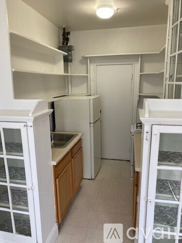 A small kitchen with a sink and a refrigerator.