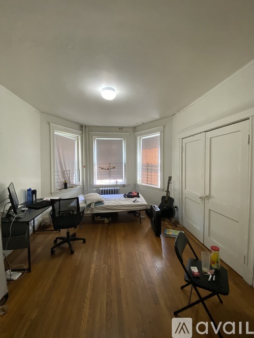 A room with a bed, desk, and chair.