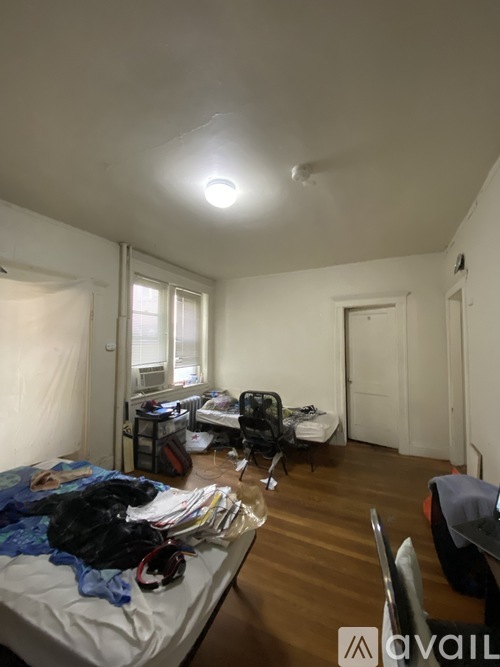 A bedroom with a bed, chair, and desk.
