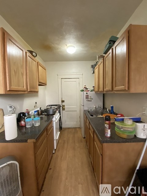 A kitchen with wooden cabinets and a black counter top.