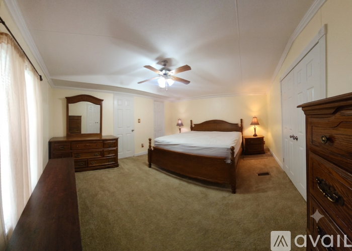 A bedroom with a bed, dresser, and mirror.