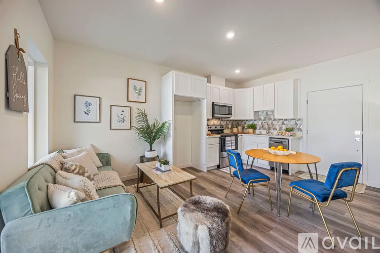 A living room with a blue chair and a white couch.